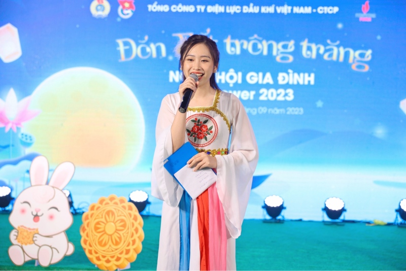 Người dẫn chương trình mặc áo dài cách tân cầm micro tại sự kiện Trung Thu