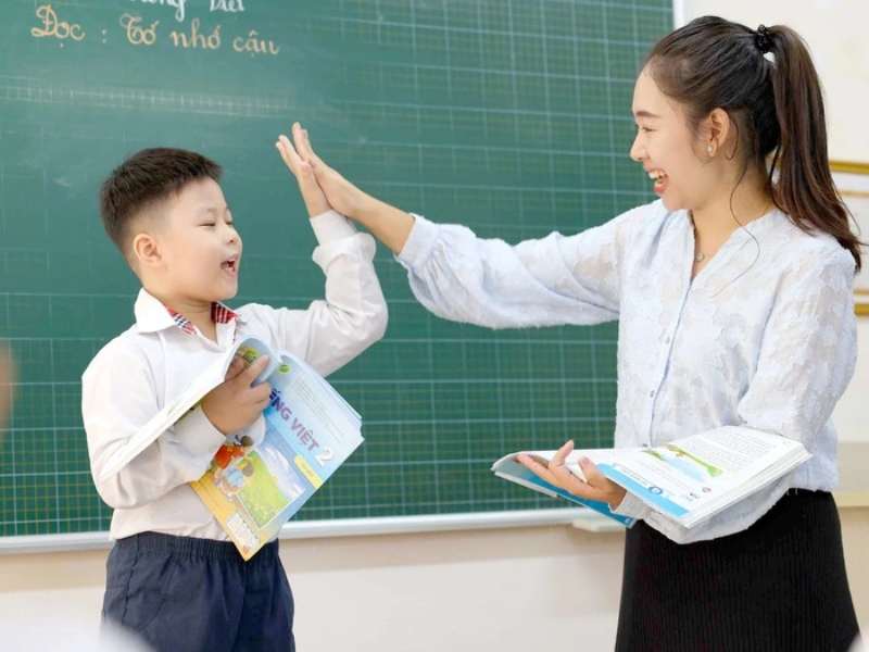 Giáo viên và học sinh đọc bài vui vẻ trên bục giảng