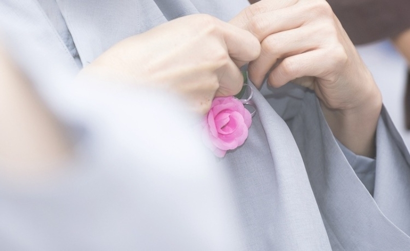 Người cài bông hồng lên áo nhân dịp ngày 20/10