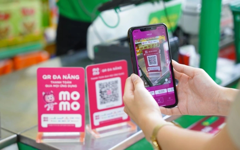 Người dùng quét mã QR MoMo để thanh toán tại quầy bằng điện thoại