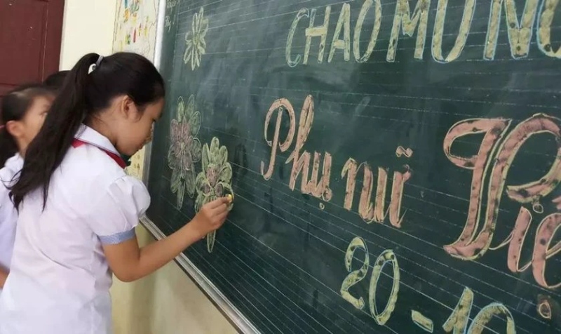 Học sinh vẽ hoa và chữ chào mừng 20/10 trên bảng