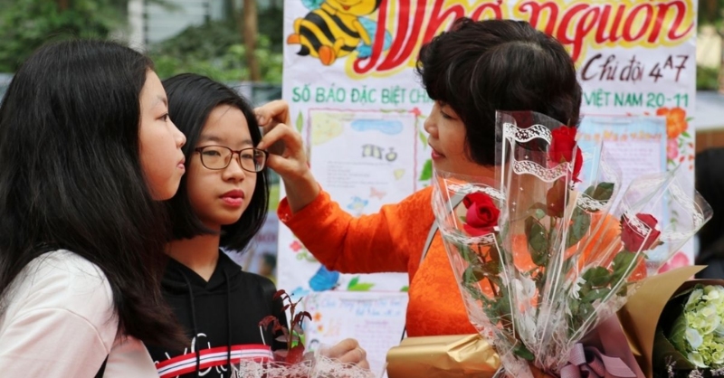 Cô giáo chỉnh tóc cho học sinh ngày lễ 20/11