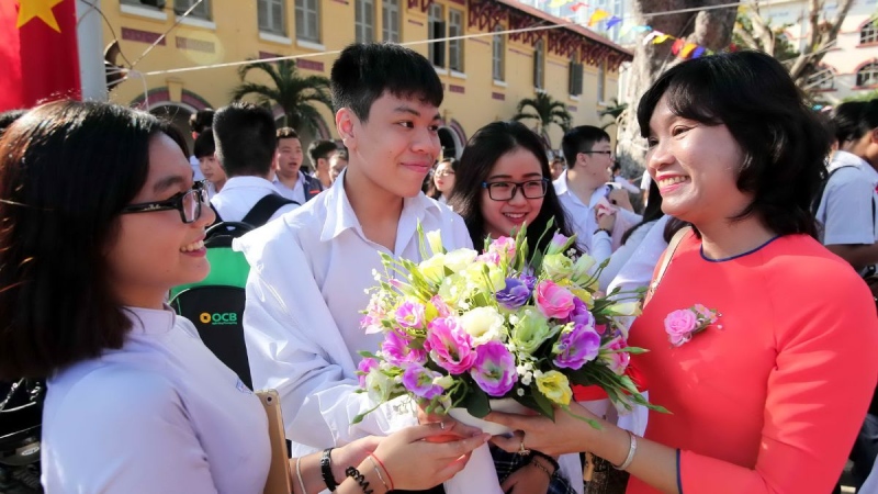 Cô giáo nhận hoa và tươi cười cảm ơn các em học sinh