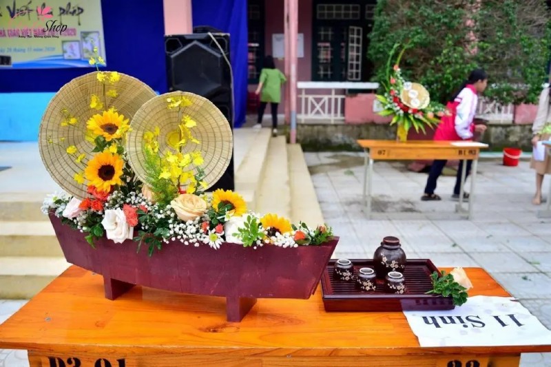 Mẫu hoa được cắm với hình dáng con thuyền và chiếc nón lá