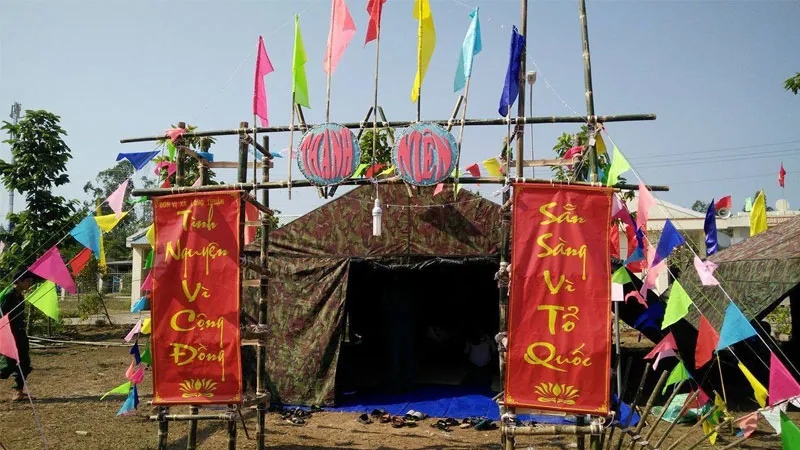 Cổng trại Thanh Niên với cờ nhiều màu và khẩu hiệu tình nguyện