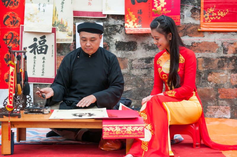 Ông đồ viết thư pháp Tết cho cô gái mặc áo dài