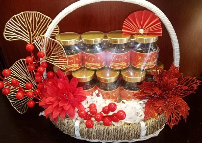 Giỏ quà Tết yến chưng được trang trí hoa đỏ và phụ kiện nổi bật