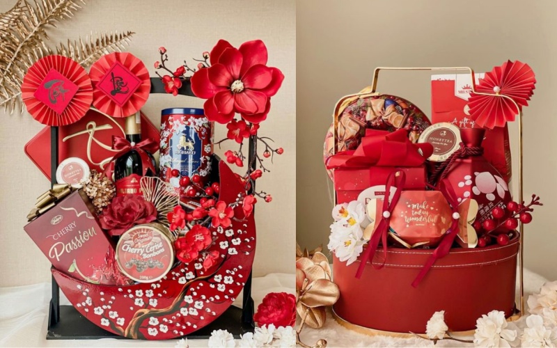 Hai giỏ quà Tết cao cấp với rượu, bánh kẹo và phụ kiện trang trí đỏ