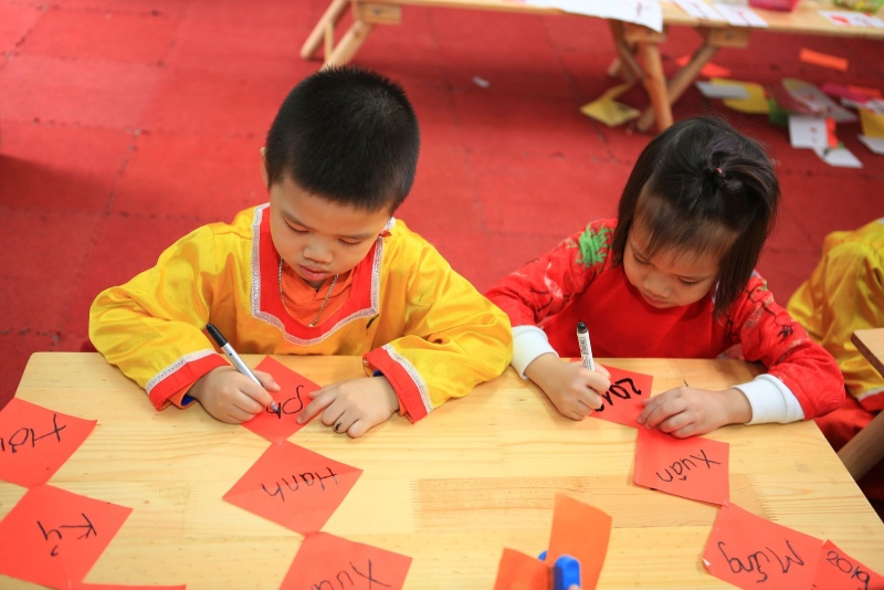 Học sinh đang viết câu đối Tết